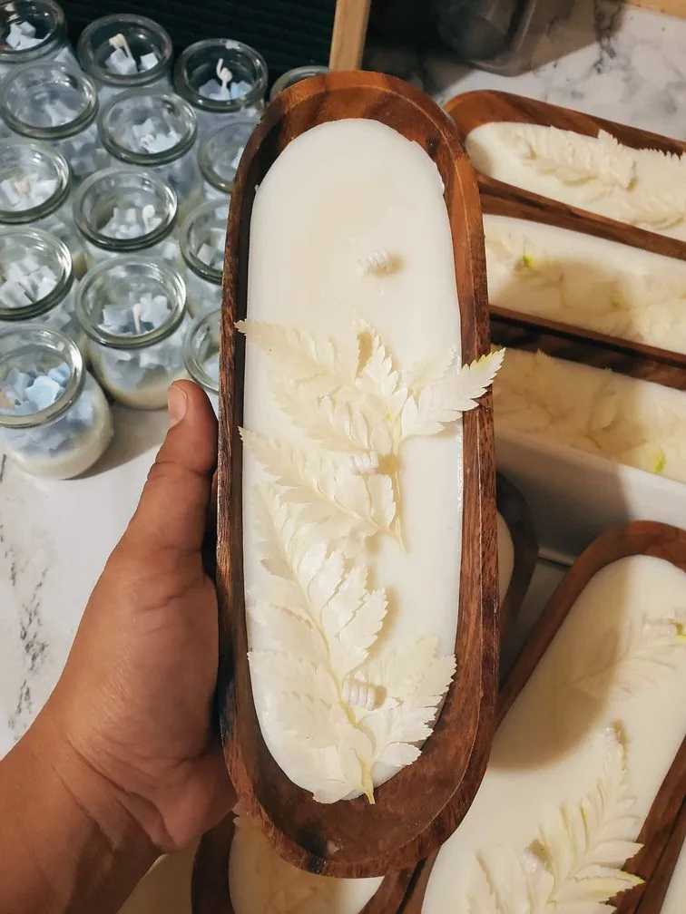 Hand holding an acacia dough bowl candle
