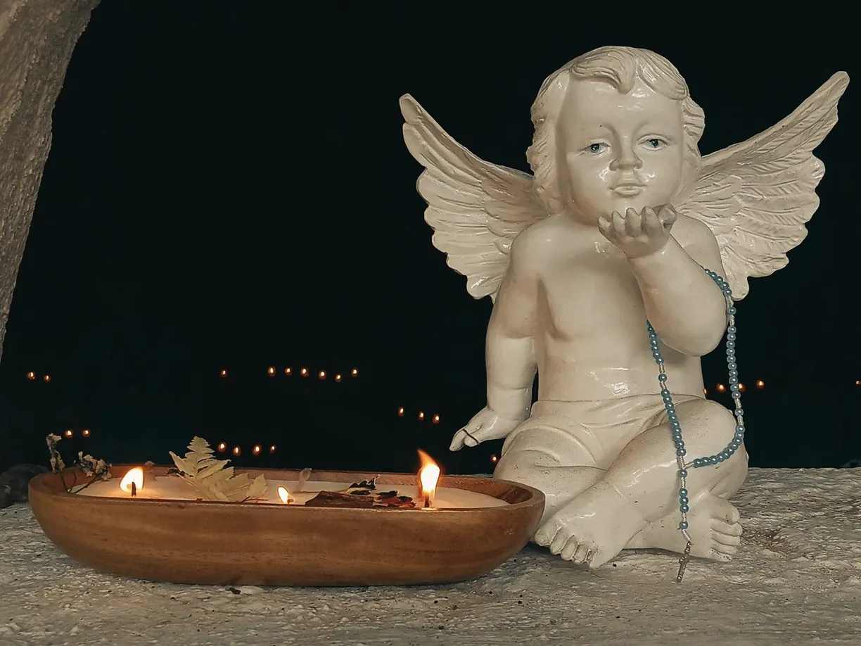 Angel figurine beside a candlelit dough bowl