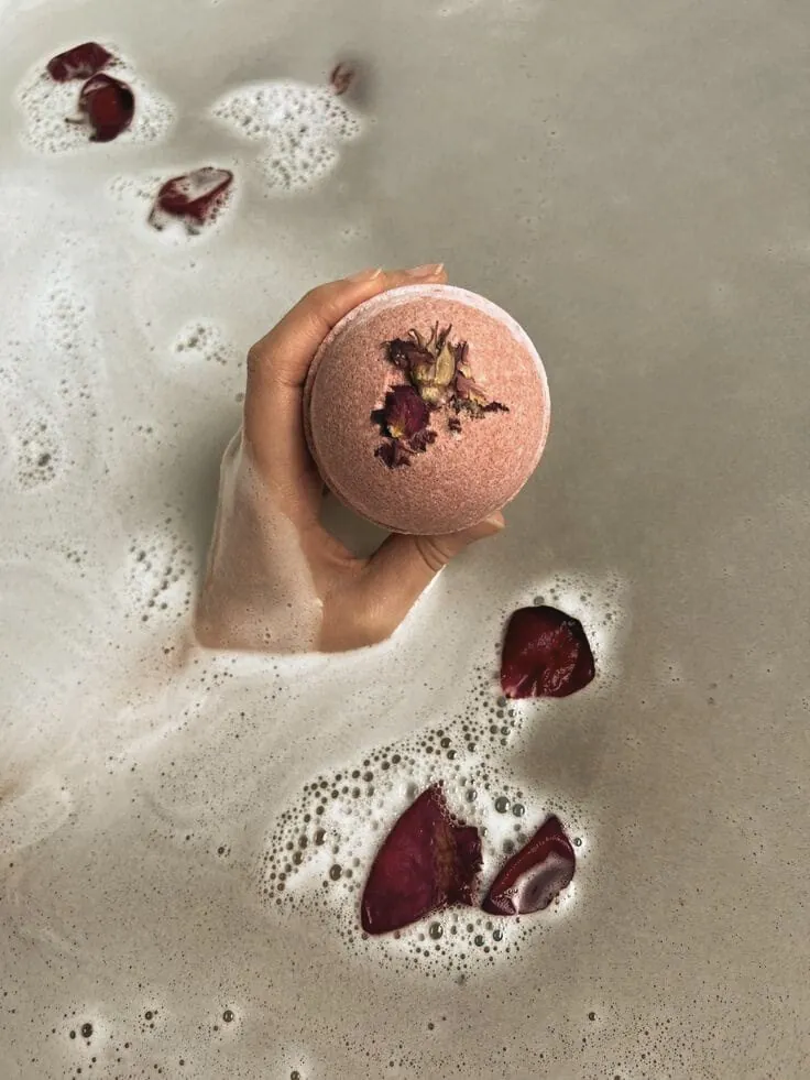 Bath bomb with rose petals in water