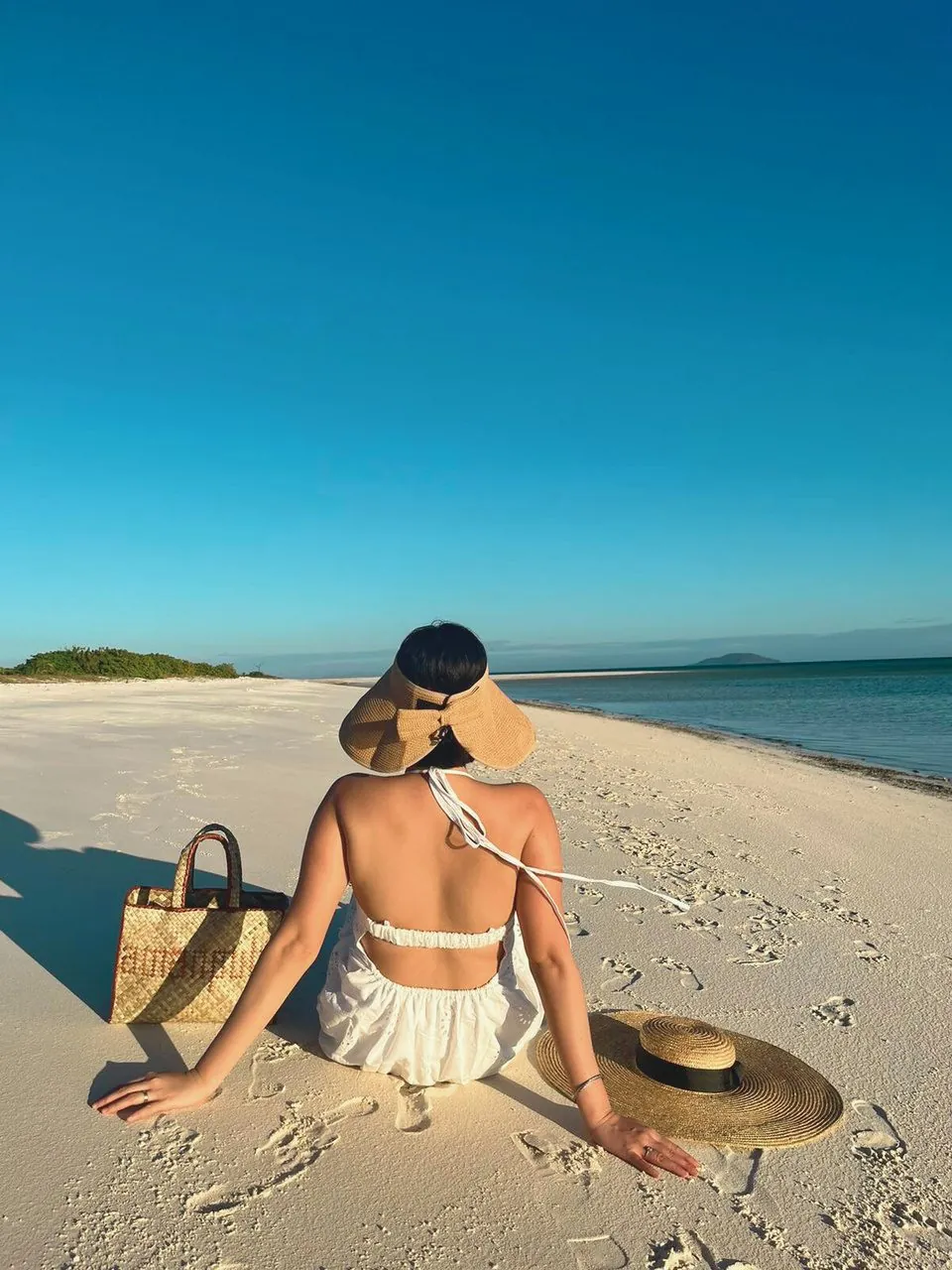 Woman resting on a white-sand beach