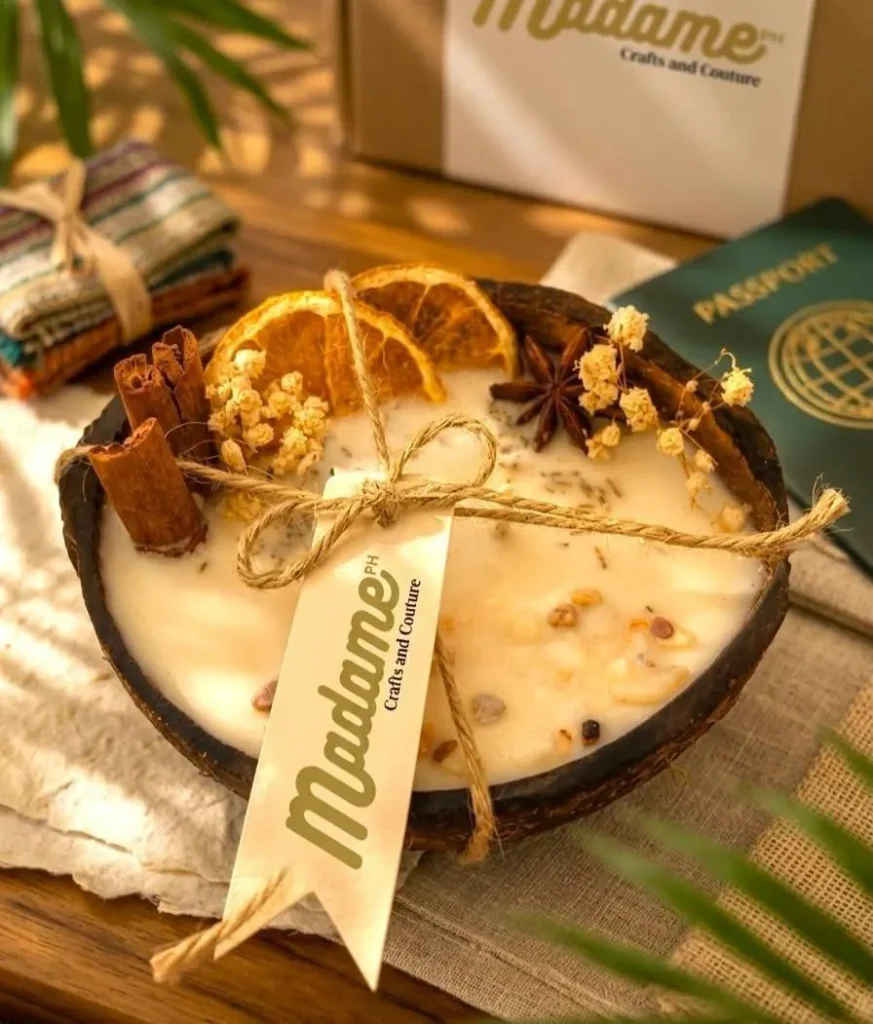 Coconut bowl candle with dried oranges beside a passport